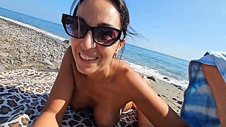 Stunning MILF is giving a quick blowjob to her husband on the beach