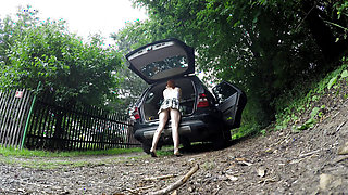 Hot redhead in short skirt loads a car