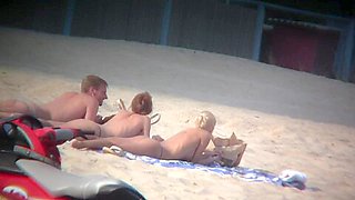 Thrilling nude friends are relaxing on a nudist beach