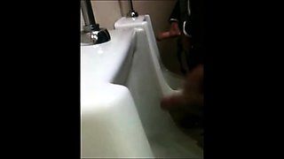 two slim dicks getting wanked at the urinals