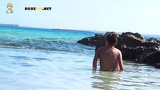 Beautiful nude beach girl enjoys a sunny day at the beach