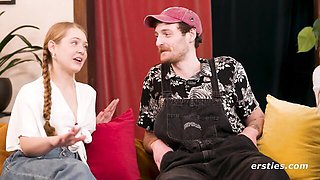 Blonde with braid and brunette talk on blue couch