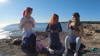 Brunettes and redheads go wild in a steamy threesome on this tropical beach