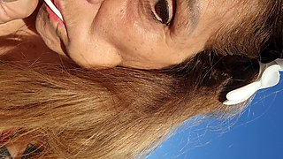 Melissa Johnson sucks and licks a cherry lollipop on the .beach